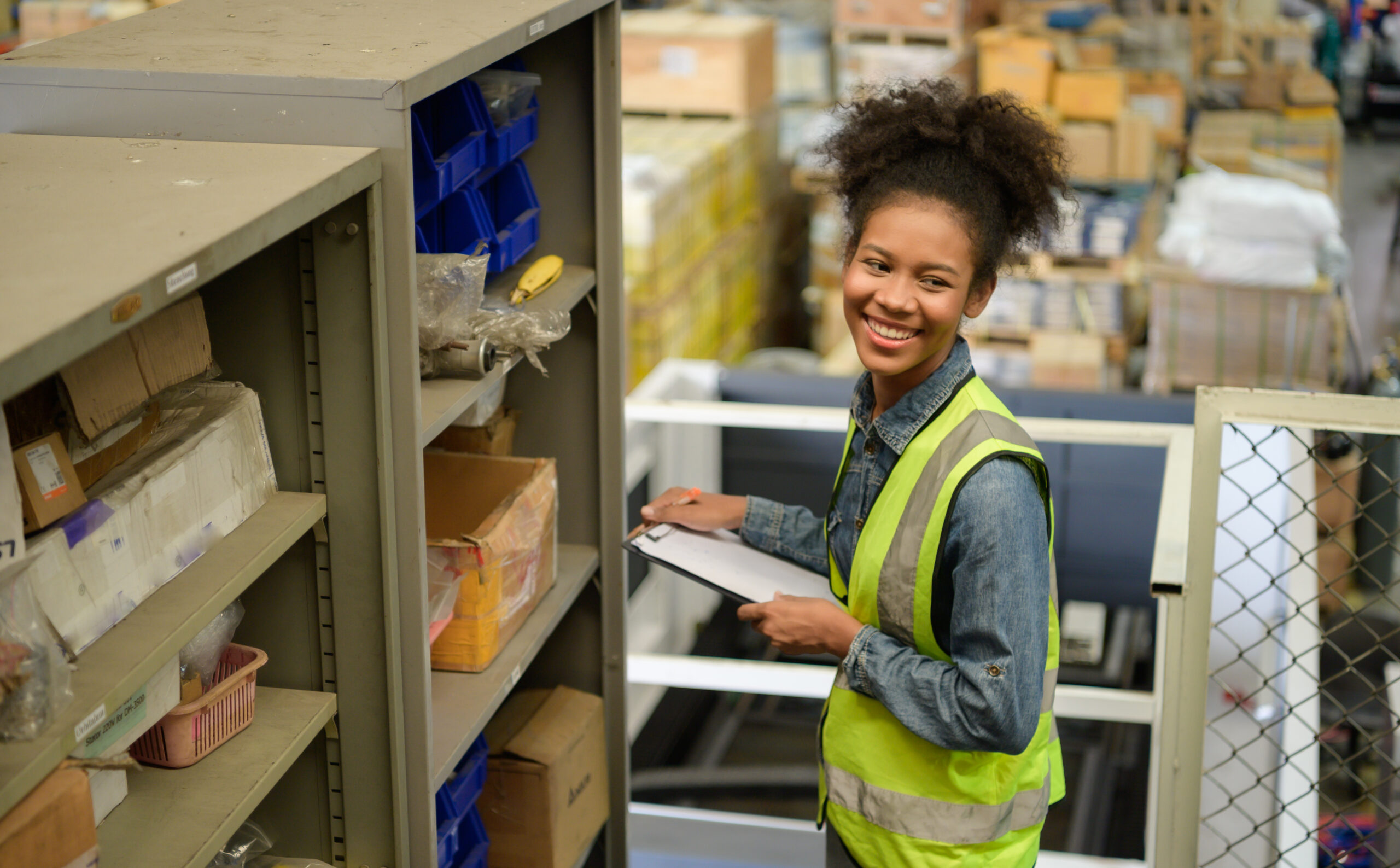 Female warehouse worker Counting items in an industrial warehous Female warehouse worker Counting items in an industrial warehouse on the factory's mezzanine floor. which is a storage for small and light electronic parts.